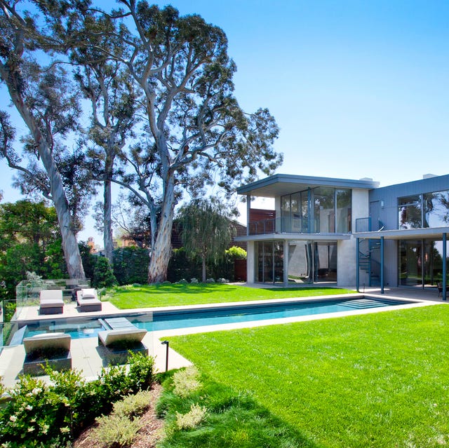 Una casa de estilo moderno con un espectacular jardín con piscina