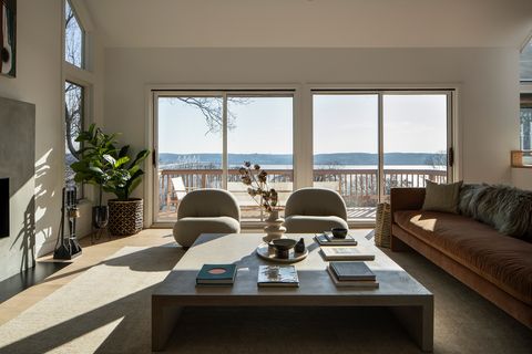 salón de diseño contemporáneo con dos butacas, un sofá y una mesa de centro de madera cuadrada