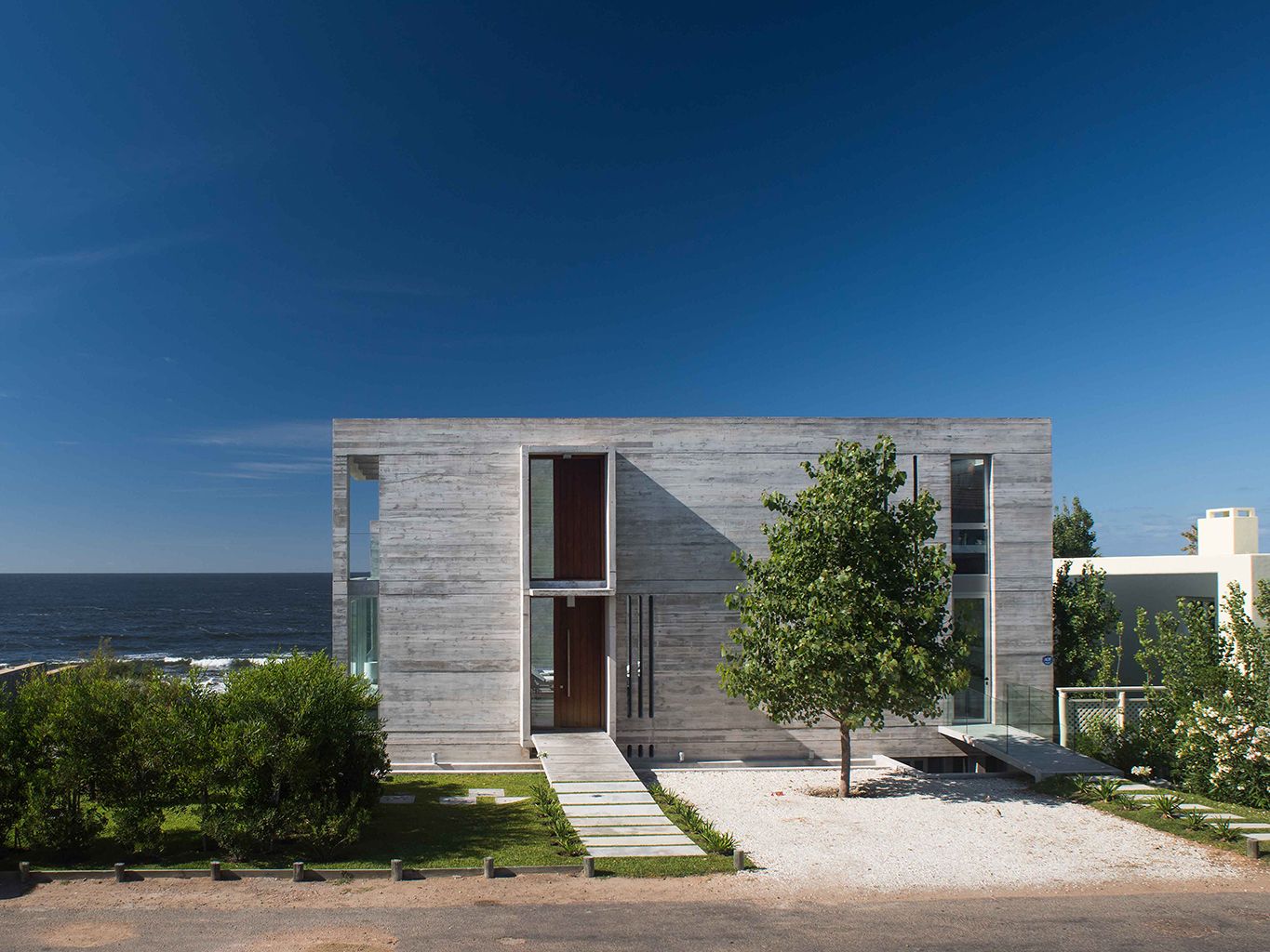 Una casa de hormigón y cristal con patio, piscina y espacios abiertos al mar