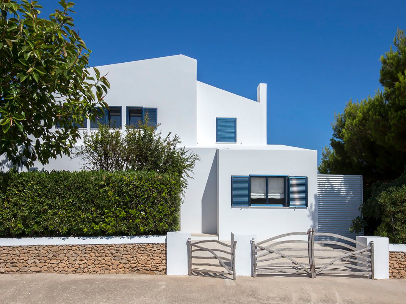 Una casa en Menorca con espacios abiertos y decorada en blanco, azul y  madera