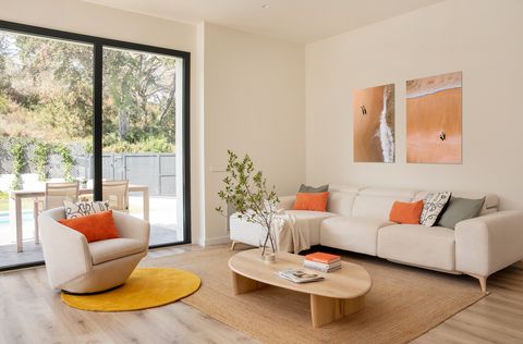 salón moderno con sofá y butaca beige y mesa de centro de madera