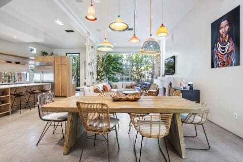 comedor abierto con mesa de madera y sillas de fibras y estilo boho