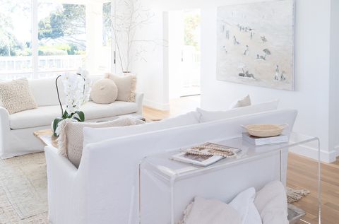 Salón decorado en blanco con dos sofás