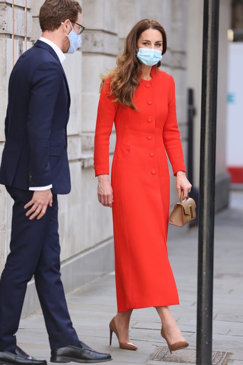 Kate Middleton Wears Red Coat With Tan Pleated Skirt And Mini Purse