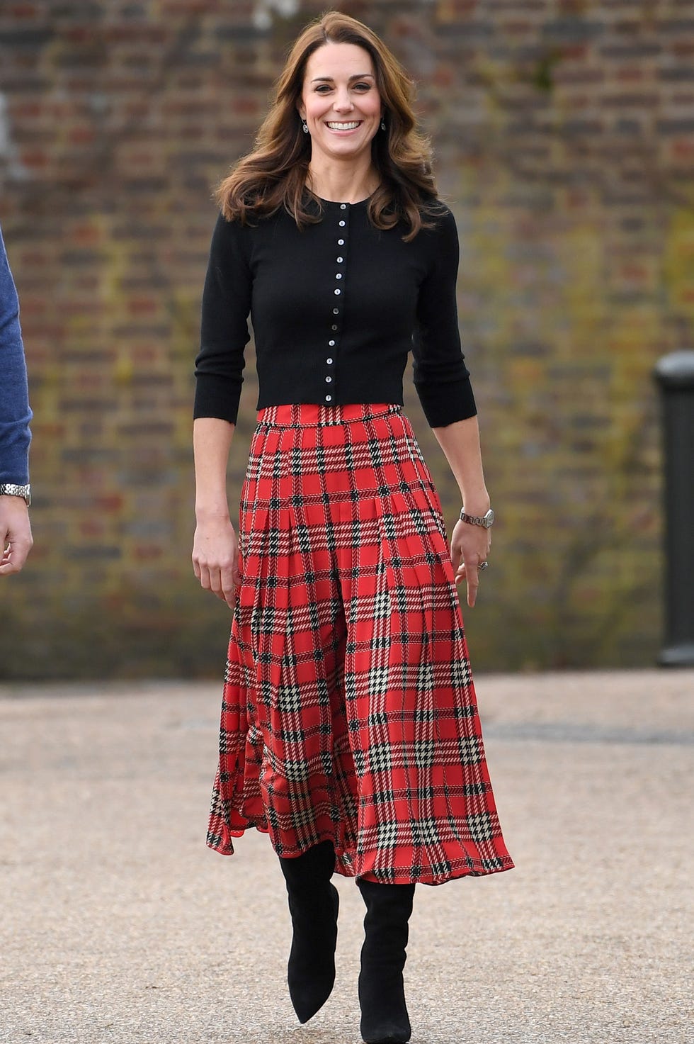Tartan midi skirt warna merah dengan cardigan warna hitam.