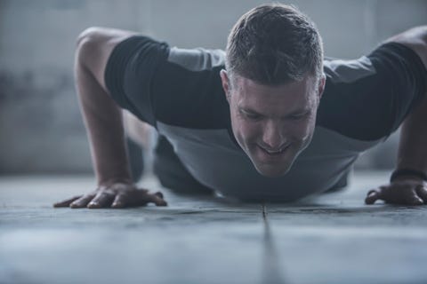 Caucasian athlete doing push-ups on floor