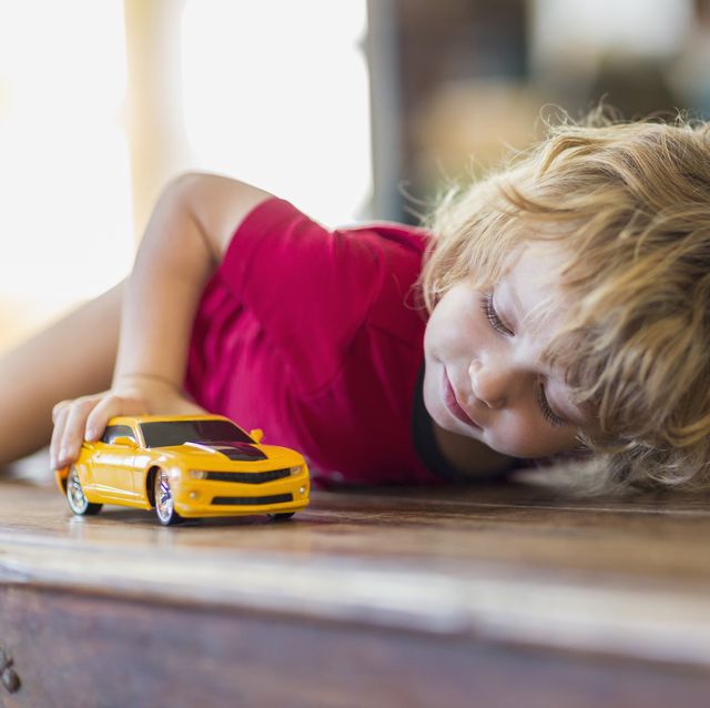 caucasian boy playing with toy car
