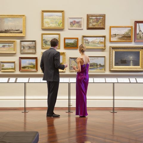 caucasian couple in evening wear admiring art in museum