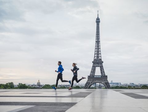 Caucasian couple running near Eiffel Tower, Paris, France
