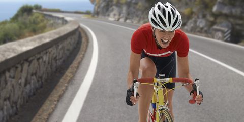 Caucasian cyclist cheering on remote coastal road