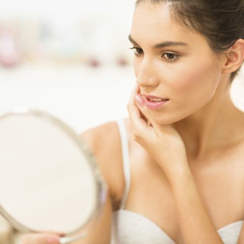 caucasian woman admiring herself in mirror