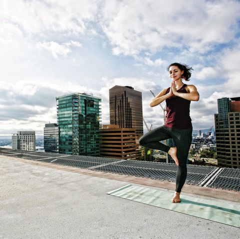 caucasian woman doing yoga urban rooftop