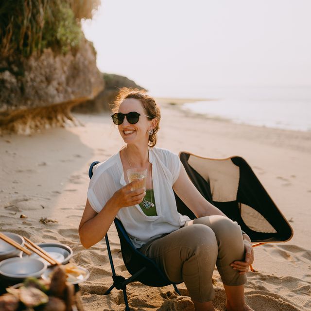 caucasian woman enjoying beach campsite at sunset