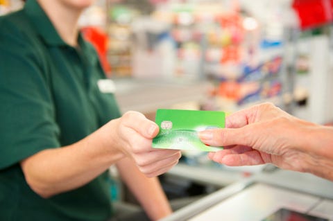 Caucasian woman paying cashier at grocery store checkout