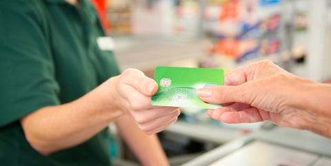 Caucasian woman paying cashier at grocery store checkout Caucasian woman paying cashier at grocery store checkout