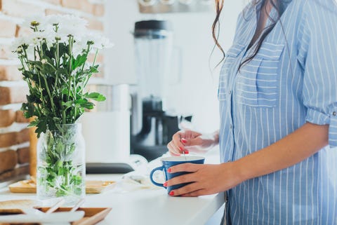 Caucasian woman stirring coffee in kitchen Caucasian woman stirring coffee in kitchen