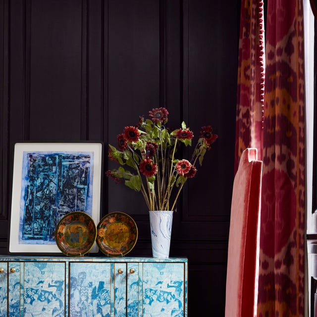 a blue and white credenza sits against an eggplant colored wall in a library