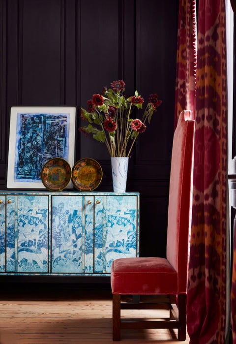 a blue and white credenza sits against an eggplant colored wall in a library