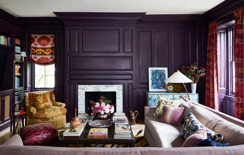 a custom mohair sectional in a library surrounds a table and the walls are a dark eggplant hue