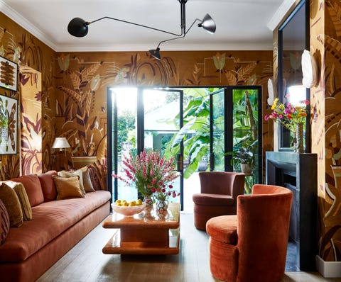 art deco inspired wallpaper headlines a warm earthen palette in a poolside sitting room off the kitchen