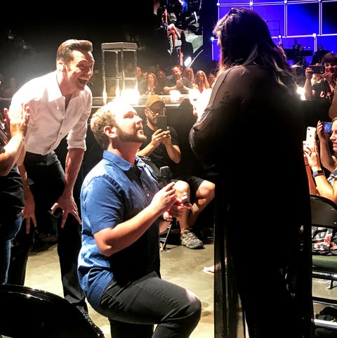 hugh jackman in the background of a couple of getting engaged