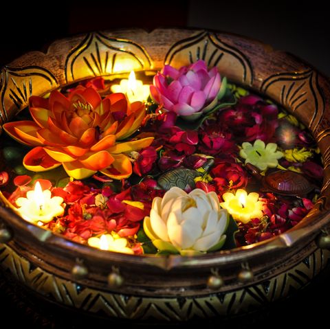 Celebration of Diwali with lit up floating candle and flower in a bowl,India.