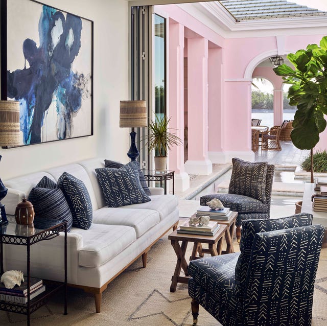 celerie kemble naples florida sunroom a sofa with two navy blue chairs in a room that opens up to an outdoor terrace