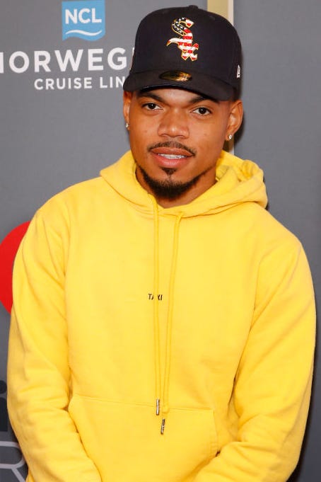Chance the Rapper chance the rapper wears a yellow hoodie and a black baseball cap on the red carpet