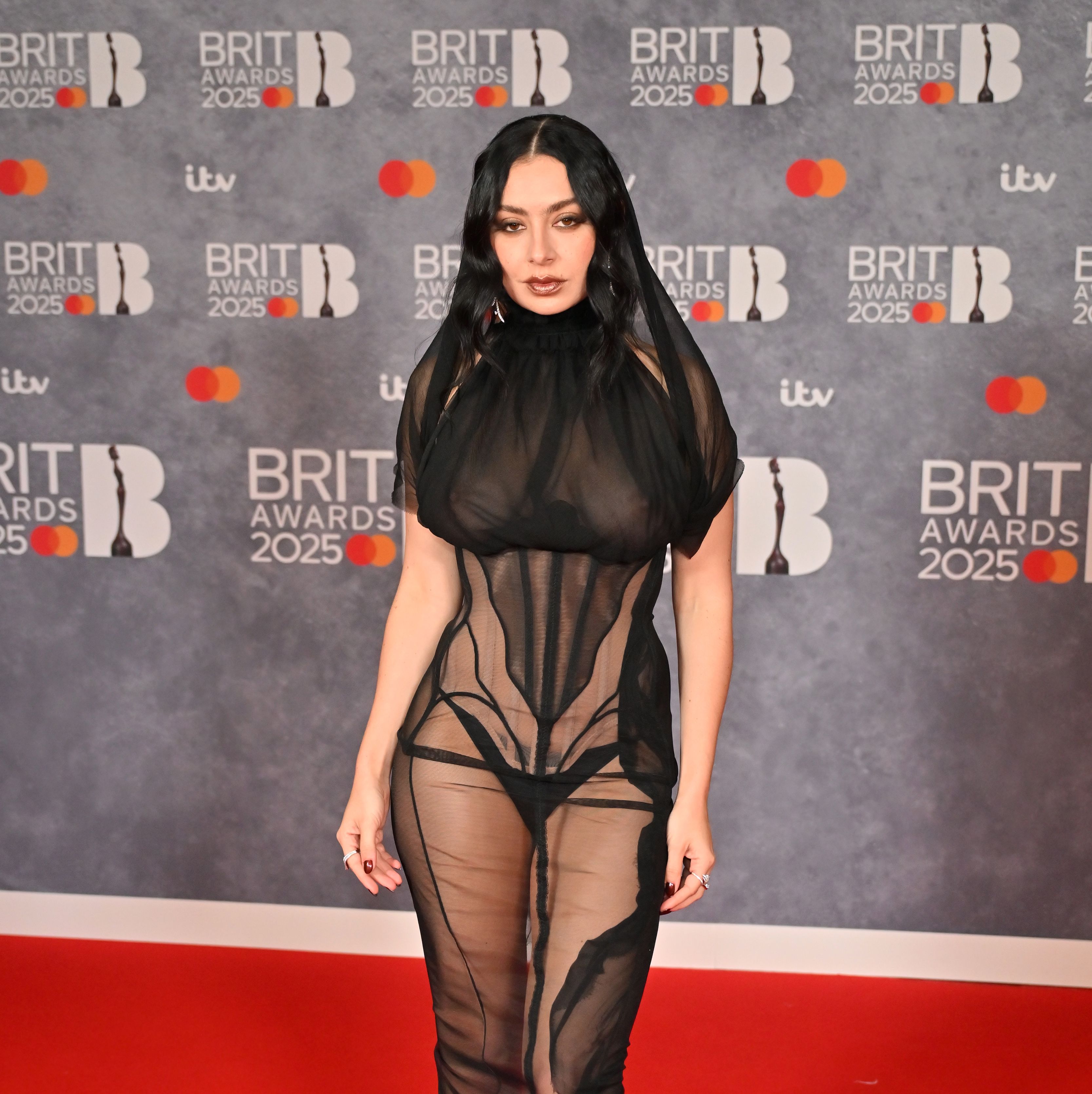 Charli XCX Arrives at the 2025 BRIT Awards in Gauzy Black Naked Dress