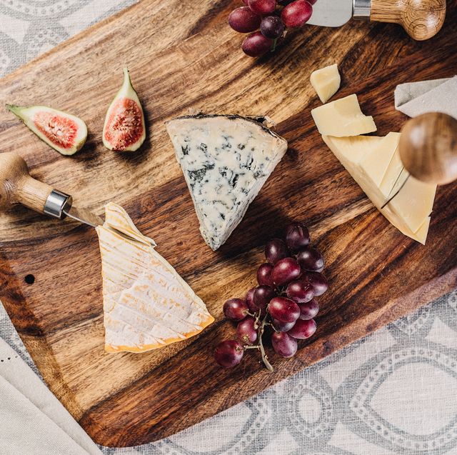 cheese figs and grapes on wooden cheese board