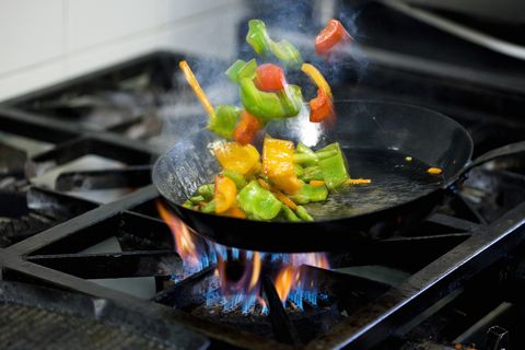 Chef frying vegetables in kitchen