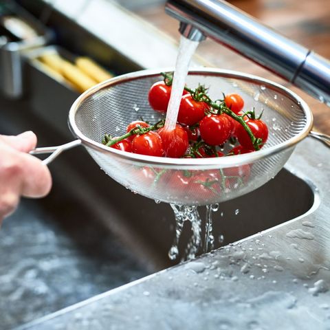 Cherry vine tomatoes being washed in sieve