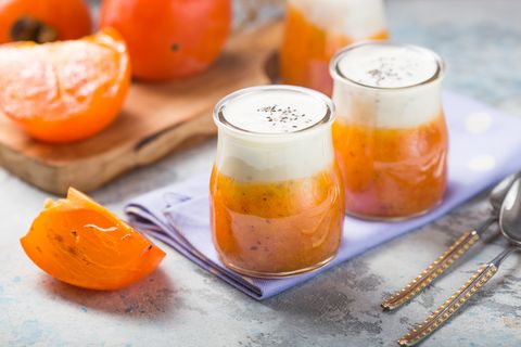 chia pudding with persimmon autumn or winter dessert light gray background healthy vegan, vegetarian breakfast table