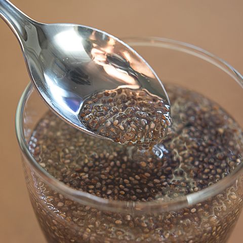 chia seeds with water in glass and spoon on table