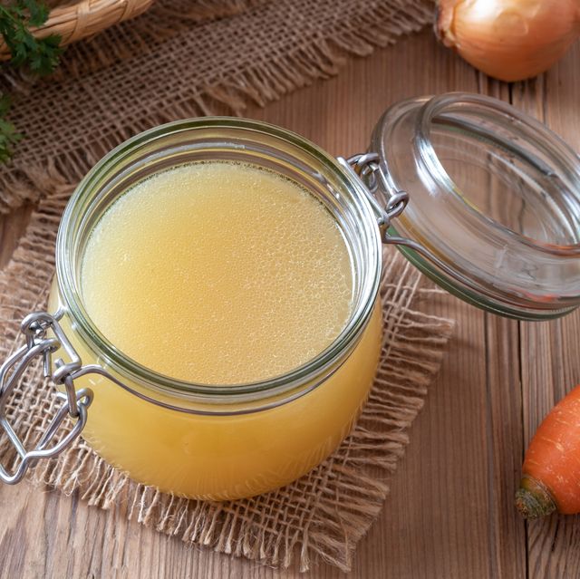 chicken bone broth in a glass jar and fresh vegetables