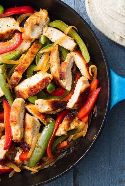 a skillet of with chicken fajitas filled with peppers and onions