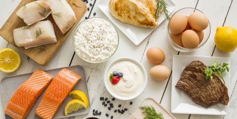 chicken meat, fish, cottage cheese, yogurt and eggs on white table