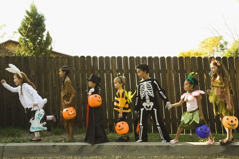 children in halloween costumes holding hands