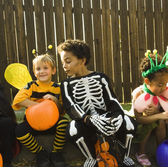 niños con disfraces de halloween mirando caramelos