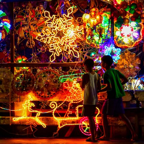 two young boys in the philippines with a light display