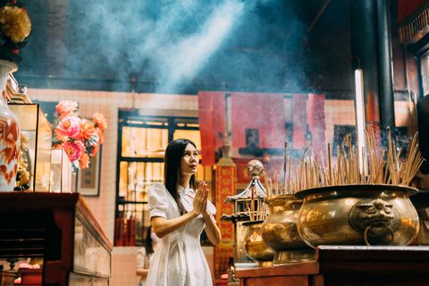 chinese woman praying sincerely in chinese temple
