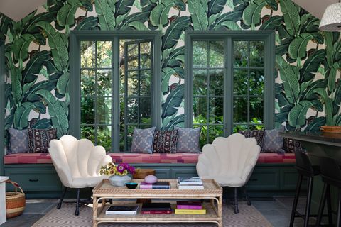 pool house with green floral walls and shell chairs