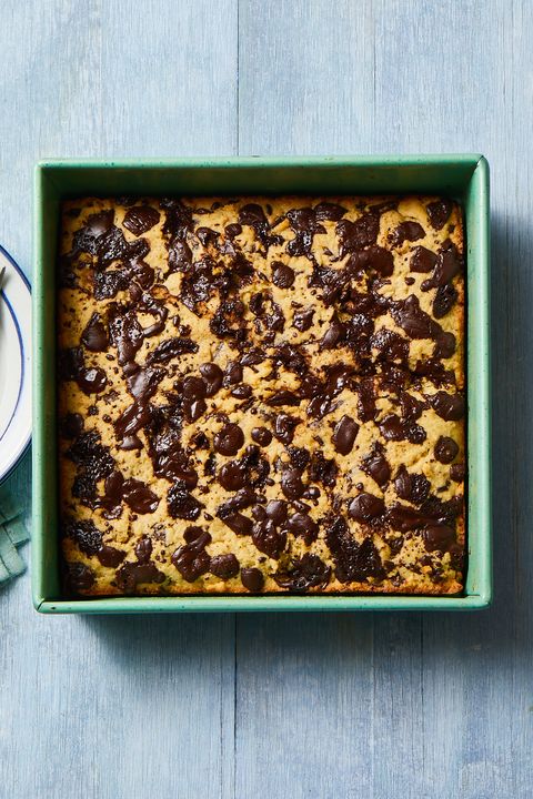 chocolate chip blondies in a green pan on a wooden table