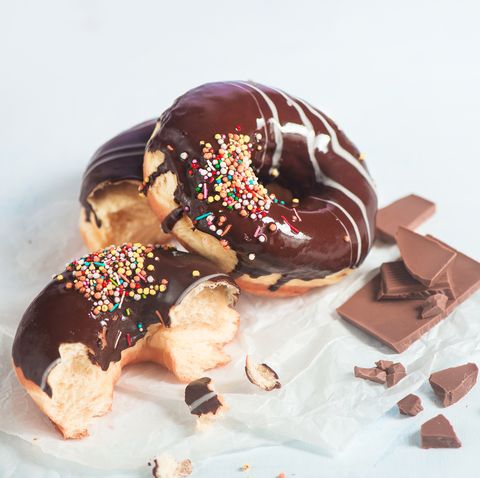 Chocolate glazed donuts with sprinkles and crumbs
