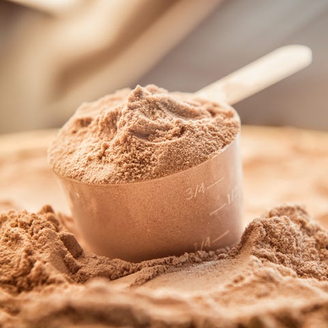 Chocolate whey protein powder with a filled scoop Chocolate whey protein powder with a filled scoop