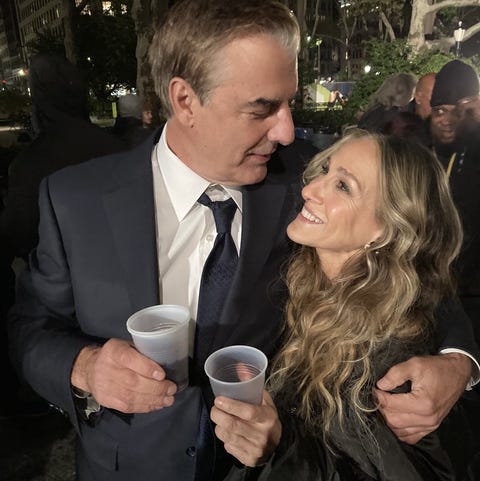 chris noth e sarah jessica parker si guardano mentre si abbracciano e tengono in mano bicchieri di plastica sul set notturno di e proprio così