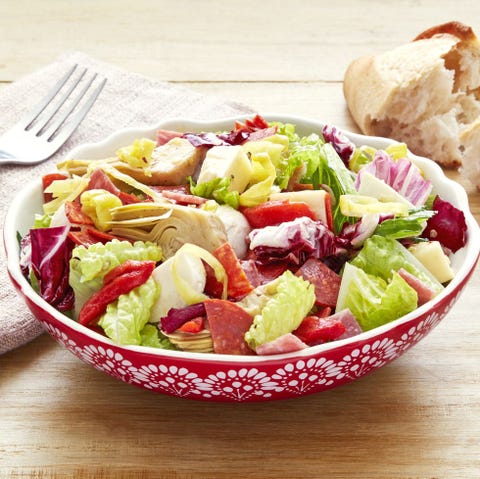 antipasti chopped salad in red bowl with bread loaf in back