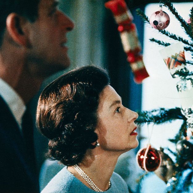 queen elizabeth and prince philip looking at christmas tree