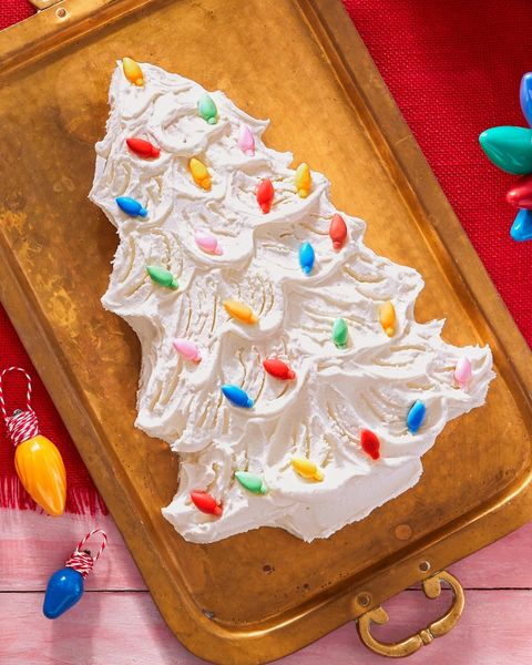 christmas tree shaped cake decorated with white frosting and colored light sprinkles