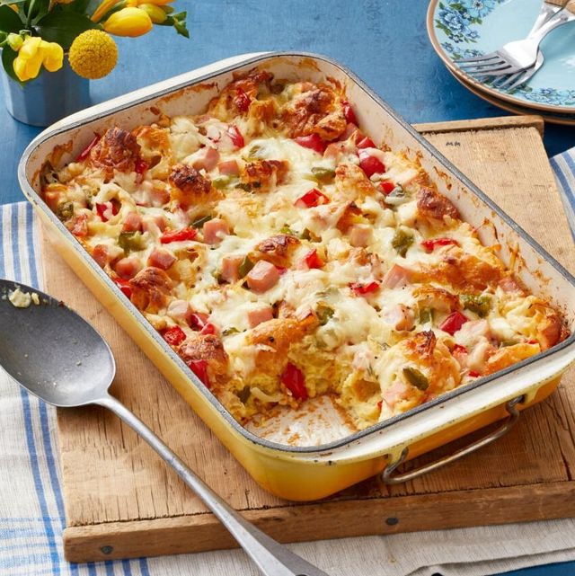 christmas casserole with peppers and ham on wood board with metal spoon